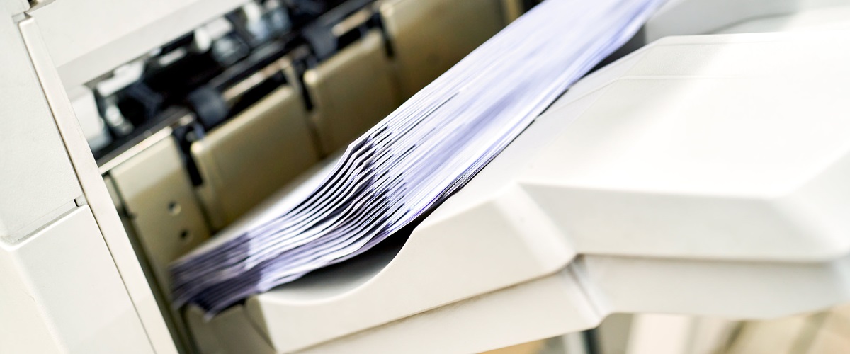 Close up view of sheets of paper inside a printer.